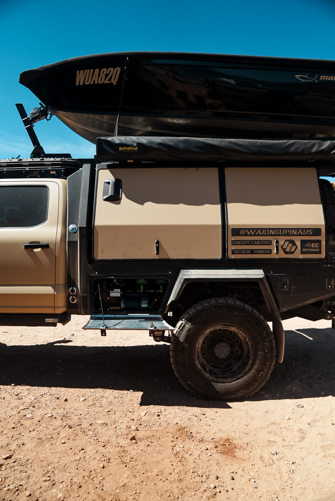The Waking up in Aus touring rig with boat on top, parked in the Australian outback with a Jedair compressor in the side access compartment
